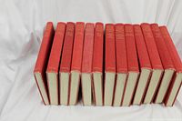 Full view of 12 volumes of Oxford Junior Encyclopedia in red hardcovers with gold lettering, showing spine arrangement and uniformity.