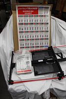 Foldable exercise frame, resistance bands attached, exercise chart, and instruction manual displayed against a white background.