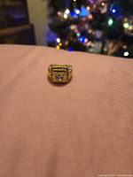 Front view of the gold plated ring showing central stone and detailed decorative square setting.