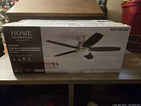 Box of Home Decorators Collection Ashby Park 52 inch LED indoor color changing ceiling fan showing brand and product image.