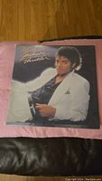 Front cover of Michael Jackson Thriller vinyl record featuring Michael Jackson in white suit jacket.