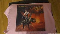 Front cover of Ozzy Osbourne The Ultimate Sin vinyl record sleeve showing character artwork and album title.