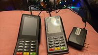 Photo showing two Verifone P400 payment terminals side by side with one power adapter cord on a surface