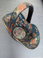 Top angle of antique Asian cloisonné basket showing floral and medallion painted design along with attached handle