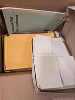 Box showing manila folders and stacks of white envelopes