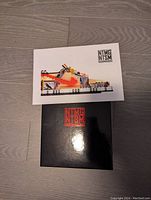 Closed box and instruction booklet showing shoe model illustration and NTMGNTSMB logo