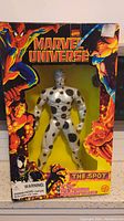 Front view of Marvel Universe The Spot action figure in original box packaging, showcasing colorful character illustrations and figure.
