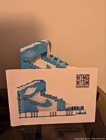 Side view of the Air Jordan UNC building block model beside instruction manual showing side profile of the sneaker.