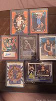 Front sides of 8 sports cards including basketball and football cards featuring signatures and jersey patches.