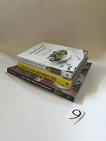 Cookbooks stacked on a white surface showing titles and condition for identification