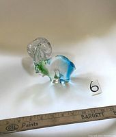 Mountain goat glass figurine showing clear, green, and blue glass with detailed clear horns and ruler for scale