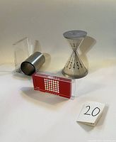 Photo showing MoMA perpetual calendar next to clock and bookend on white background.