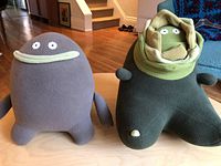 The two Monster Factory plush dolls Buddy and Wilma side by side on table, showing size and color differences.
