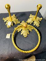 Three-piece vintage brass bathroom set including two robe/towel hooks and one towel ring with ornate decorative bases