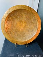 Front view of vintage hammered silver wall art showcasing circular shape, hammered outer rim texture, and engraved botanical motifs.