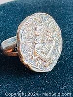 Front view of vintage sterling silver ring showing mother and child design with floral background on oval face.
