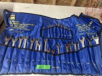 Photo of 30 piece wrench set rolled out on table with blue fabric case.