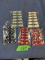 Five packs of fake nails arranged neatly on a blue surface, showing different background colors and floral designs for each pack.