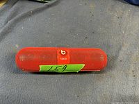 Front view of the red Beats Pill Bluetooth speaker showing mesh grille and Beats logo.