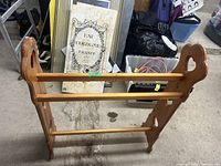 Wooden blanket rack with heart-shaped cutouts on two side panels and three horizontal bars for hanging items.