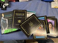 Photo showing spread of multiple oracle cards from the Wisdom of the House of Night deck, plus the guidebook and packaging box.