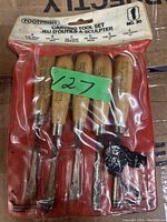 Set of five Footprint wood carving tools in original packaging with wooden handles and metal blades visible.