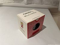 Box with Keith Haring and Bella Maison branding, featuring red and white design with cut-out window showing mug inside.