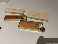 Vintage sealing wax sticks in red and black in gold tray with cream paper box labeled 'British Sealing Wax and Seal'.