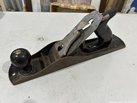 Full view of Stanley No.5 wood hand plane showing wooden front knob and rear handle, metal body with blade adjustment mechanism.