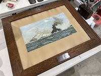 Framed WW1 religious naval print on beige mount with oak frame and bottom plaque, viewed at angle