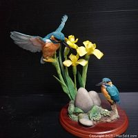 Full view of the kingfisher figurine displaying two birds, yellow flowers, gray eggs, and wooden base.