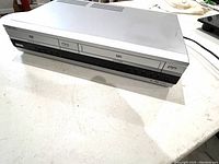 Front view of the Sony DVD and VHS player unit showing the DVD tray and VHS cassette slot, silver finish and button controls.