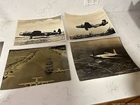 Top view of the four WW1 Royal Airforce black and white photographs arranged on a white surface showing vintage aircraft and one aerial shot with naval ship.
