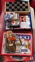 Overall lot view showing checkers board, playing cards, and darts in boxes