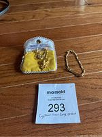 Pendant and bracelet arranged next to Charles Jewelry pouch