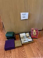 Complete lot showing watch in display case and several jewelry boxes opened with various pieces inside.