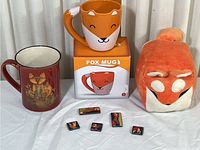 Full lot with two mugs, five magnets, and plush cube shown