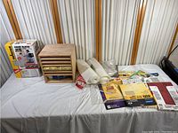 Full lot view showing boxed Wagner Power Painter 317E, wooden drawer organizer, sanding sheets and rolls spread out on table.