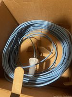 Coiled blue CAT 5 cable inside a large cardboard box showing length and color