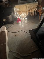 Front angle showing illuminated metal reindeer with white lights and red bow around neck.