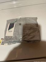 Photo of the medium men's IZOD golf shirt folded and sealed in original clear plastic packaging with visible IZOD Golf tag and barcode tags.
