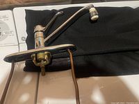 Photo showing the top side of the chrome kitchen faucet with single lever handle and base plate, laying on black cloth.