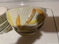 Close-up photo of a single Mariposa bowl showing textured surface and yellow-brown leaf design.