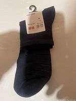 One pair of men's blue half socks in dark blue color with label showing care instructions and size information.