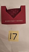 Front view of Geoffrey Beene tie box with tie inside showing brand name and red textured box.