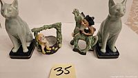 Front view showing two green ceramic cat bookends, dwarf on wishing well, and man on donkey figurine with identification number 35