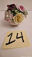 Front side showing multicolored flowers arranged in a basket with a handwritten label '14'.