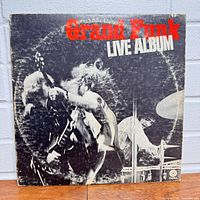 Front cover of Grand Funk Live Album vinyl record LP showing black and white live photo and red and white text.