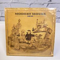 Front of sealed 45 RPM single with brown illustration of dock and character and text Modest Mouse King Rat