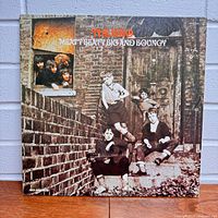 Front cover of 'Meaty Beaty Big and Bouncy' album by The WHO with band members pictured sitting on brick steps.